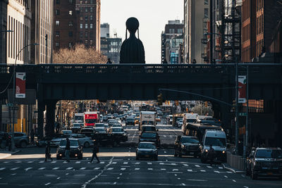 Rear view of people on city street by buildings