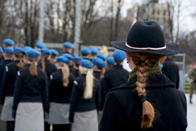 Rear view of woman in uniform standing outdoors