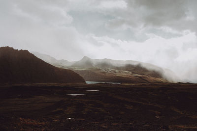 Scenic view of mountains against cloudy sky