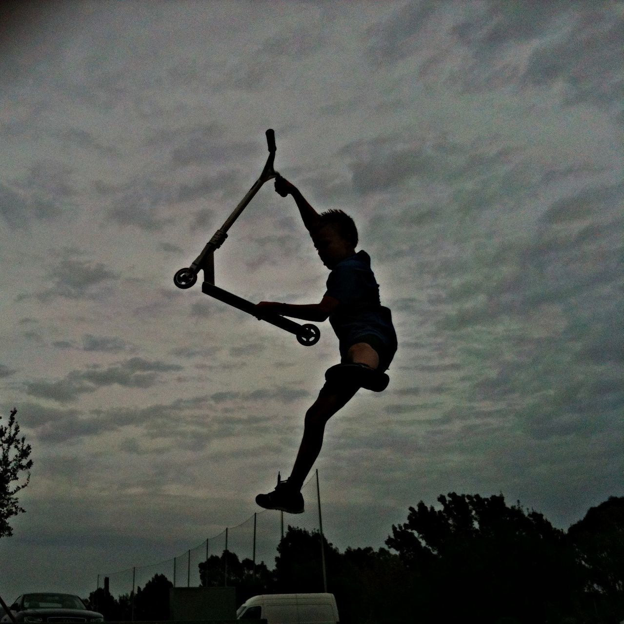 full length, lifestyles, leisure activity, men, sky, mid-air, skill, silhouette, jumping, tree, motion, transportation, holding, outdoors, low angle view, sport, day, bicycle