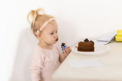 High angle view of cute girl eating food on table