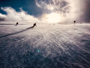 People on snowy field against sky