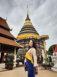 Portrait of smiling woman standing against temple