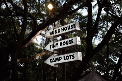 Low angle view of information sign against trees