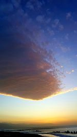 Scenic view of sea against dramatic sky during sunset