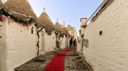 Footpath amidst buildings against sky