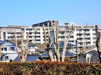 Buildings in city against clear blue sky