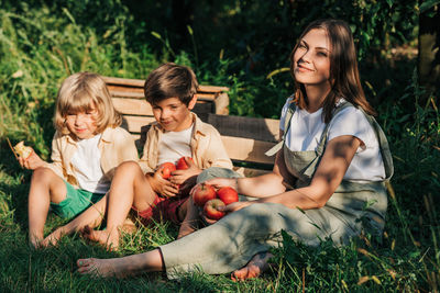 Portrait of smiling friends sitting on field