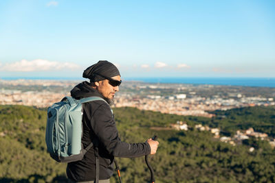 Rear view of man standing against sky during sunset