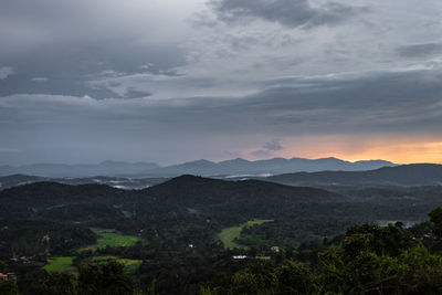 Mountains range misty shadow with dramatic colorful sunset sky at dusk from flat angle