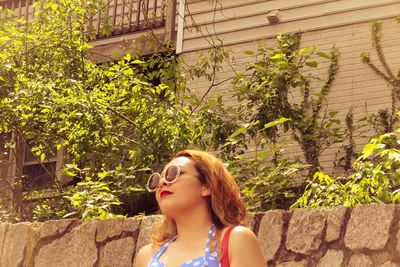 Beautiful young woman against plants