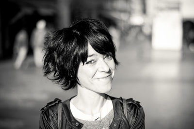 Portrait of smiling young woman with short hair on street