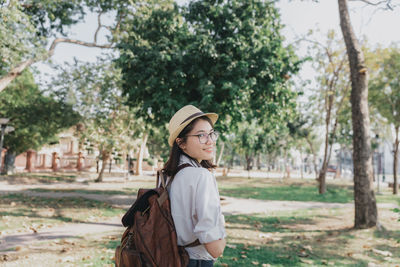 Side view of young woman standing on field