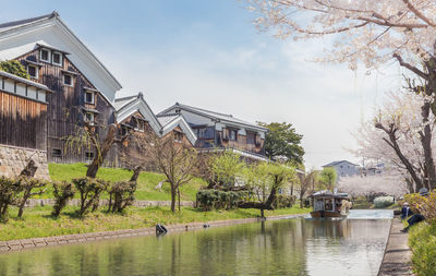 Jikkokubune boat with tourists passing gekkeikan okura sake museum in fushimi, kyoto, japan