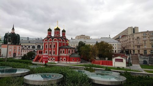 Buildings in city against cloudy sky