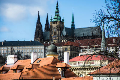 Houses by st vitus cathedral against sky