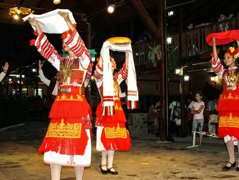 Full length of women wearing traditional clothing dancing at night
