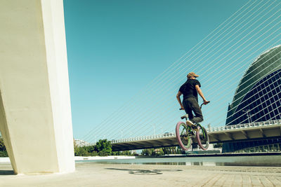 Man riding bmx cycle on footpath in city