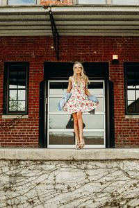 Young woman standing against building