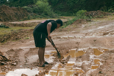 Full length of man working on dirt road