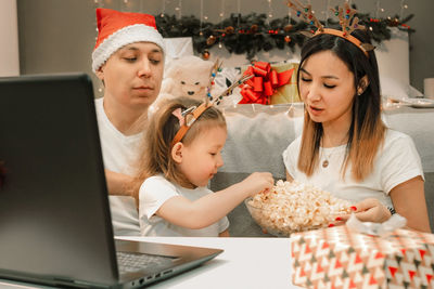 Portrait of young woman using laptop at home