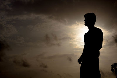 Silhouette man standing against sky during sunset