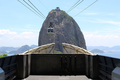 Low angle view of overhead cable car against sky