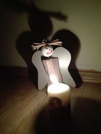 Close-up of lit candle on table at home