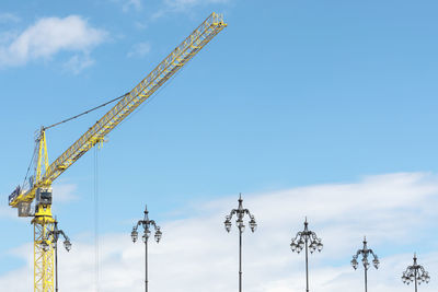 Low angle view of cranes against sky