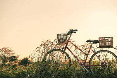 Bicycle on field against clear sky