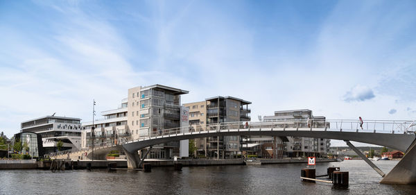 Bridge over river in city against sky