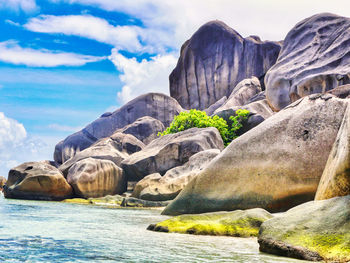 Rocks on sea shore against sky