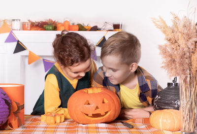 Boy playing with jack o lantern on table