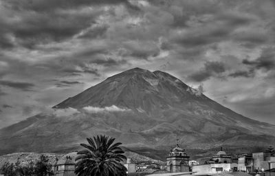 View of trees and mountain against cloudy sky