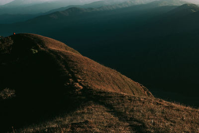 Scenic view of land and mountains against sky