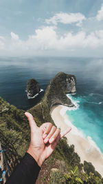 Midsection of person holding sea against sky