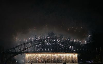 Low angle view of illuminated fireworks against sky at night