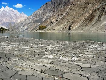 Scenic view of lake by snowcapped mountains against sky