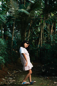 Full length of woman standing in forest