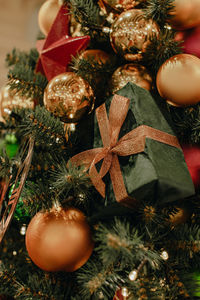 Creative christmas tree decorated with christmas balls, red stars, golden watch and  gift boxes