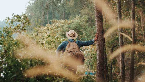 Rear view of woman standing in forest