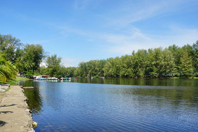 Scenic view of river by trees against sky