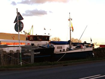 Boats moored at harbor against sky