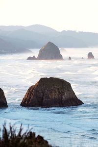 Scenic view of rocks in sea against sky