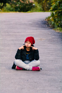 Portrait of boy sitting on road