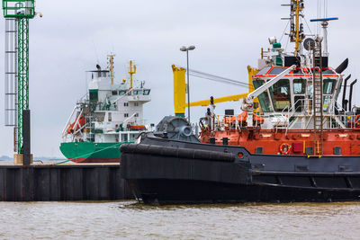 Boats moored at harbor against sky