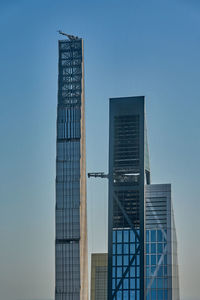 Low angle view of modern buildings against clear blue sky