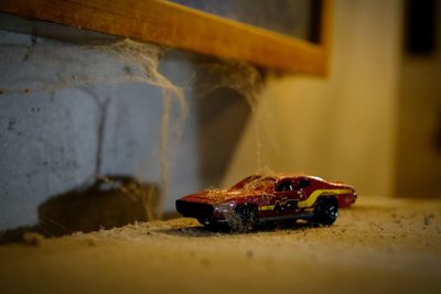 Close-up of rusty toy car on wall