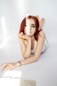 Woman model with fresh daily makeup and short red hair in studio.