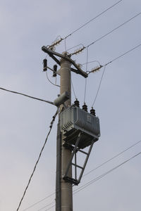 Low angle view of electricity pylon against clear sky